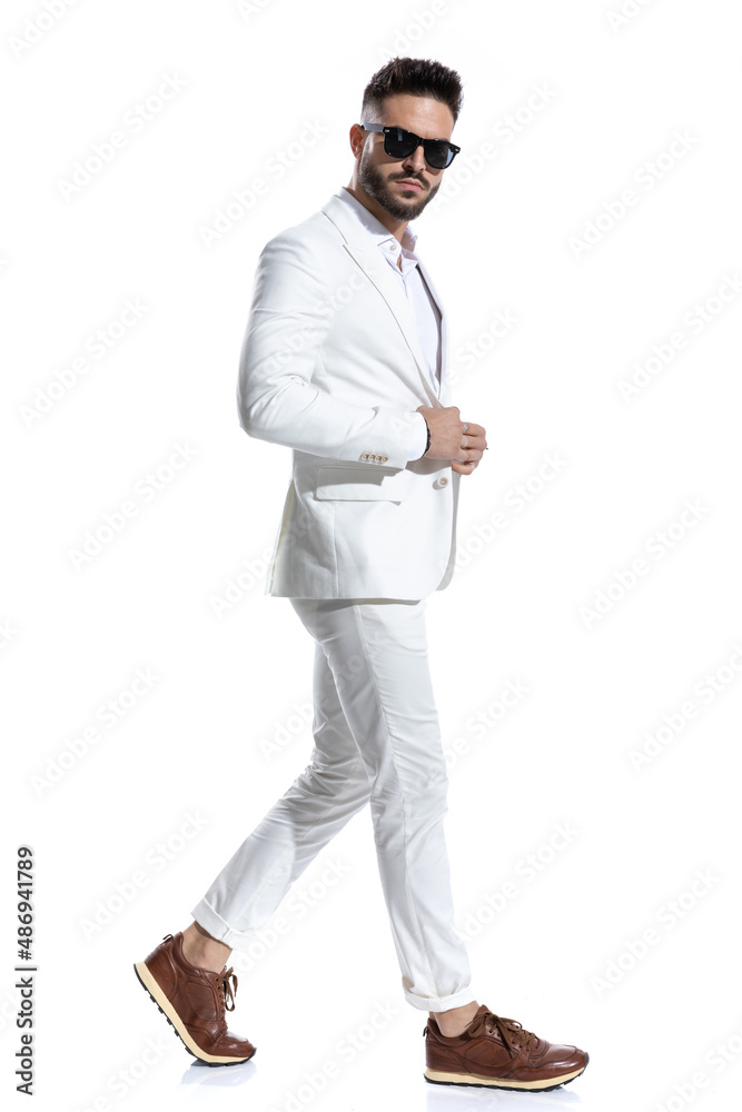 side view of bearded businessman with glasses buttoning suit side view of bearded businessman with glasses buttoning suit