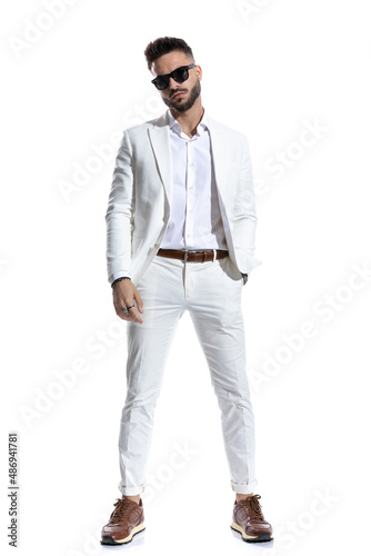 bearded businessman with eyeglasses holding hand in pocket and posing