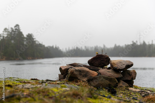 Camp fire site with lake in background. Wintertime grey day with no visible people