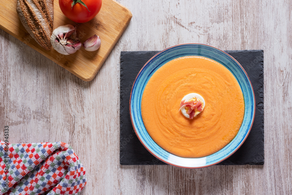 Salmorejo dish with ham and egg, along with the ingredients used for its preparation.