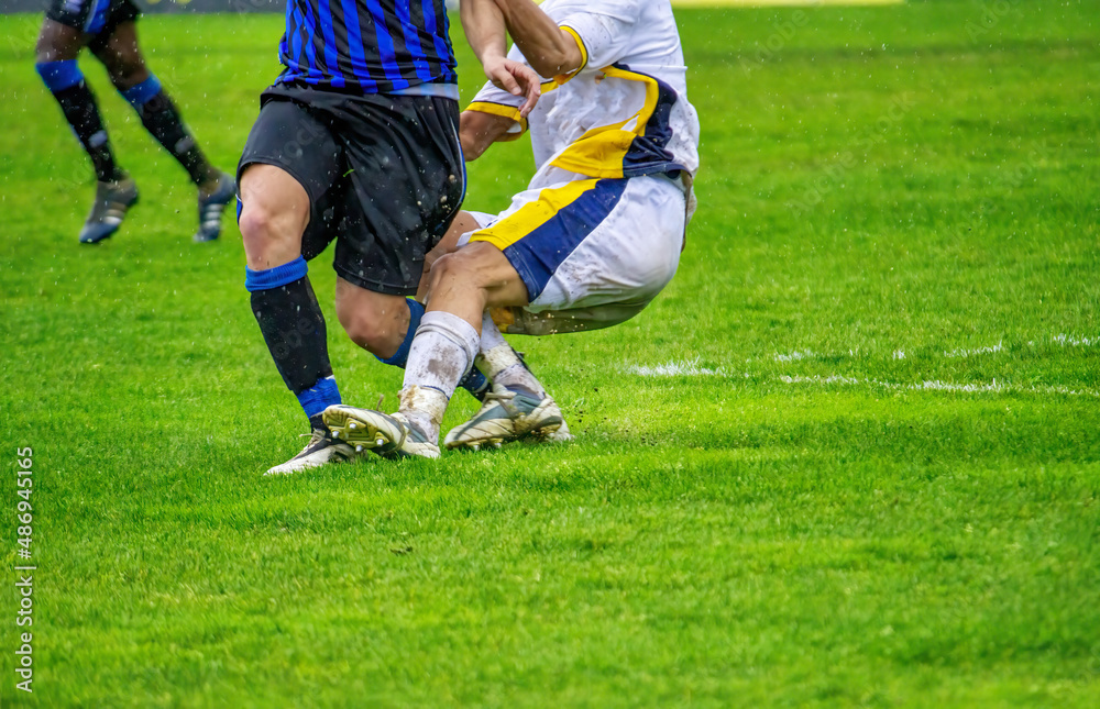 Soccer players tackling in the football pitch. Soccer players tackling in the football pitch.