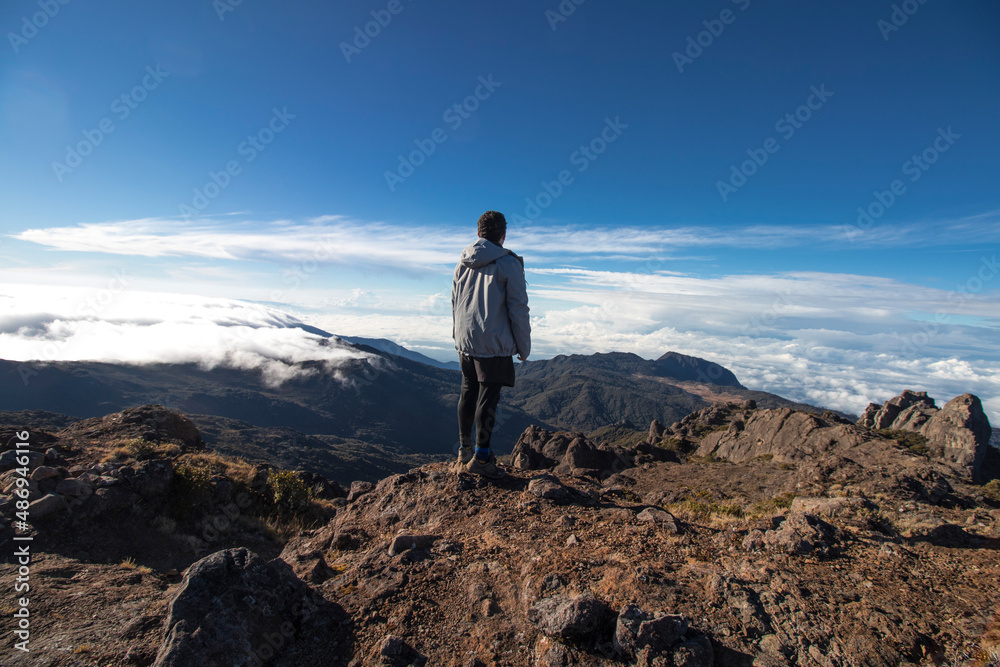 man contemplating the landscape of rocky mountains with paramo vegetation in Chirripo National Park man contemplating the landscape of rocky mountains with paramo vegetation in Chirripo National Park