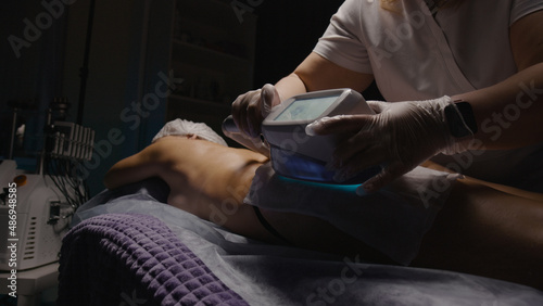 Woman getting cryolipolysis anti-fat anti-cellulite freezing treatment procedure in spa salon. Hardware cosmetology. Wellness body and skin care, beauty treatment, receiving rejuvenation procedure