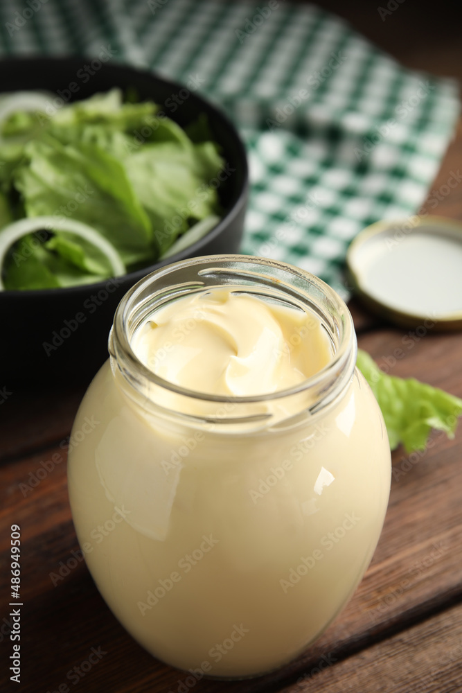 Jar of delicious mayonnaise and fresh salad on wooden table Jar of delicious mayonnaise and fresh salad on wooden table