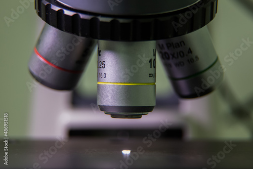 closeup of a microscope lens pointing at a specimen