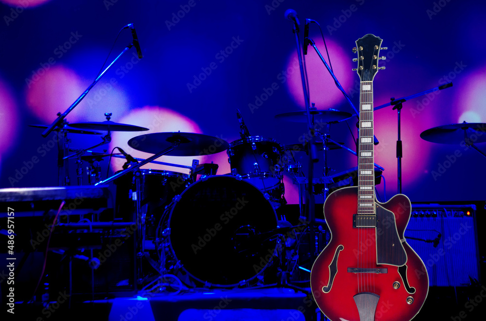 Electric guitar on the background of the stage with musical instruments.  Stock Photo | Adobe Stock