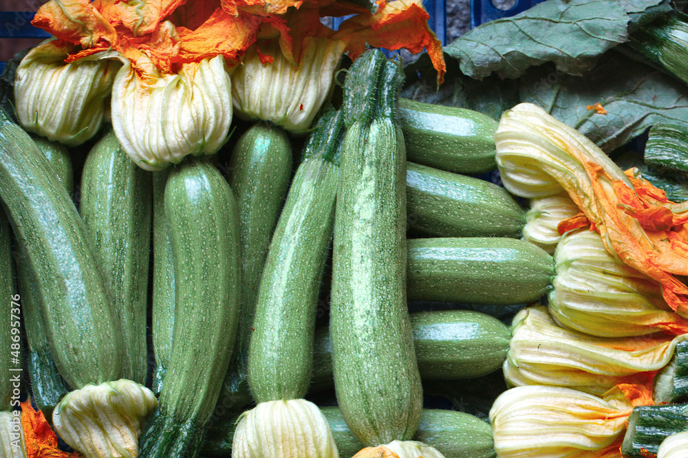Fresh young green zucchini vegetables with yellow flowers, stacked in rows exactly.
Abstract theme healthy Italian food