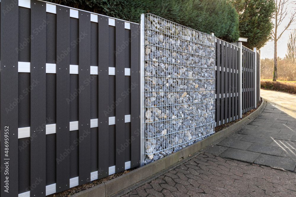 Modern gabion wall system with stones as element of garden or house wooden metal fence Modern gabion wall system with stones as element of garden or house wooden metal fence
