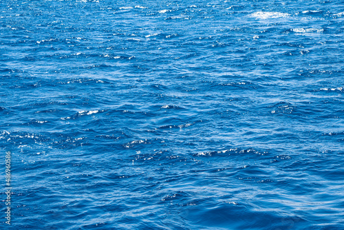 Seawater background. Blue sea with little waves texture. The unique color of the water. Seawater surface texture.