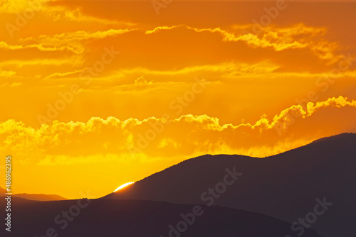 The sun rising early in the morning above the hills of Greece.