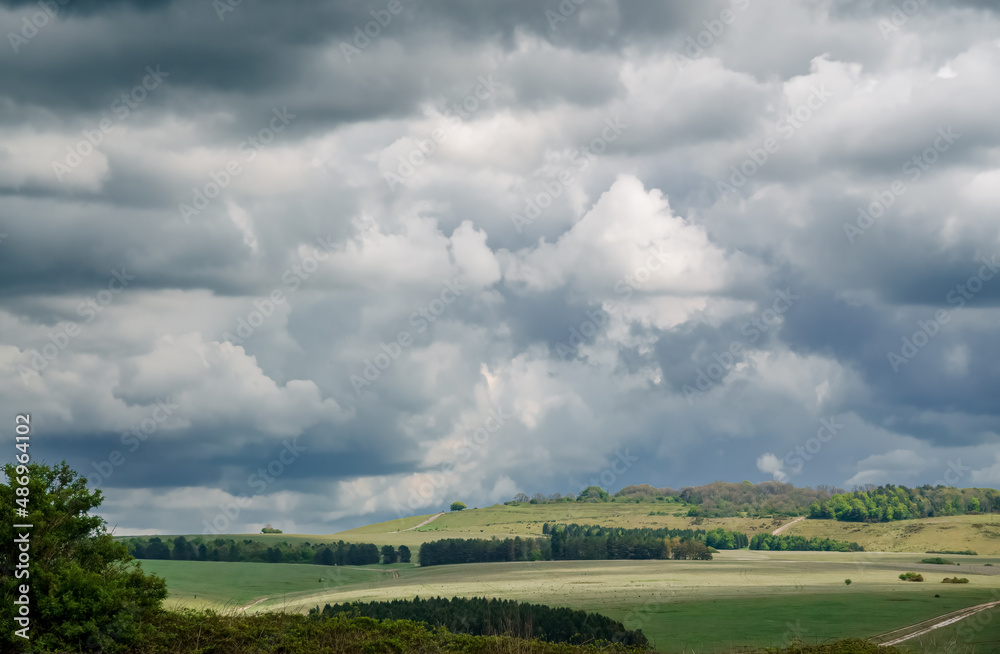 a foreboding dramatic dark grey thunder storm cloud sky over a tump and green meadows on Salisbury Plain, Wiltshire a foreboding dramatic dark grey thunder storm cloud sky over a tump and green meadows on Salisbury Plain, Wiltshire