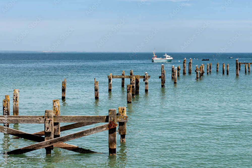 Remains of old pier with a boat in the background