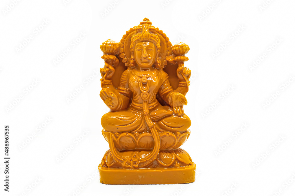The statue of Mahalakshmi carved in wood is isolated in white The statue of Mahalakshmi carved in wood is isolated in white