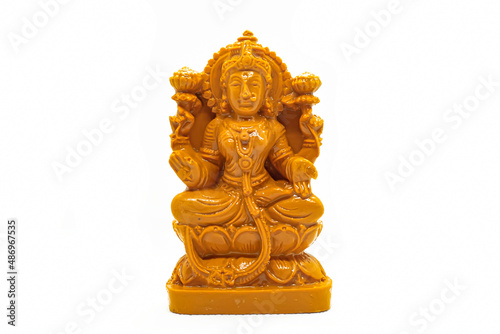 The statue of Mahalakshmi carved in wood is isolated in white photo