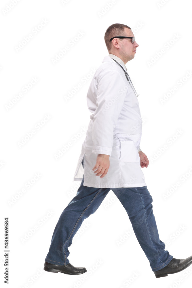 Fototapeta premium Full length studio shot of walking young male doctor with stethoscope, side view