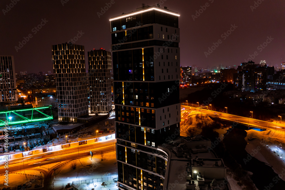 night panorama of residential area with high-rise buildings with road and motor transport, modern illumination of buildings. Futuristic style. Yekaterinburg, Russia