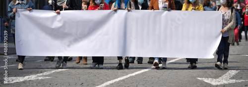Grupo de pessoas numa manifestação de rua a segurar uma tela em branco - colocar mensagem - sexo feminino - setas no pavimento da estrada  photo