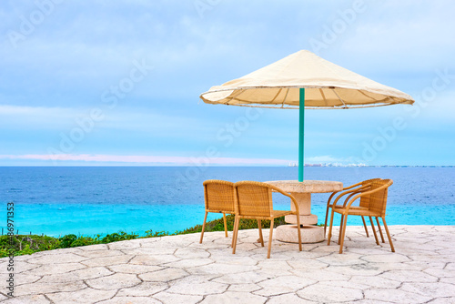 beach umbrella and chairs in front of the beach in isla mujeres mexico. mexican caribbean beaches