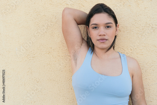 Young woman with unshaven armpits confidently looking at the camera. photo