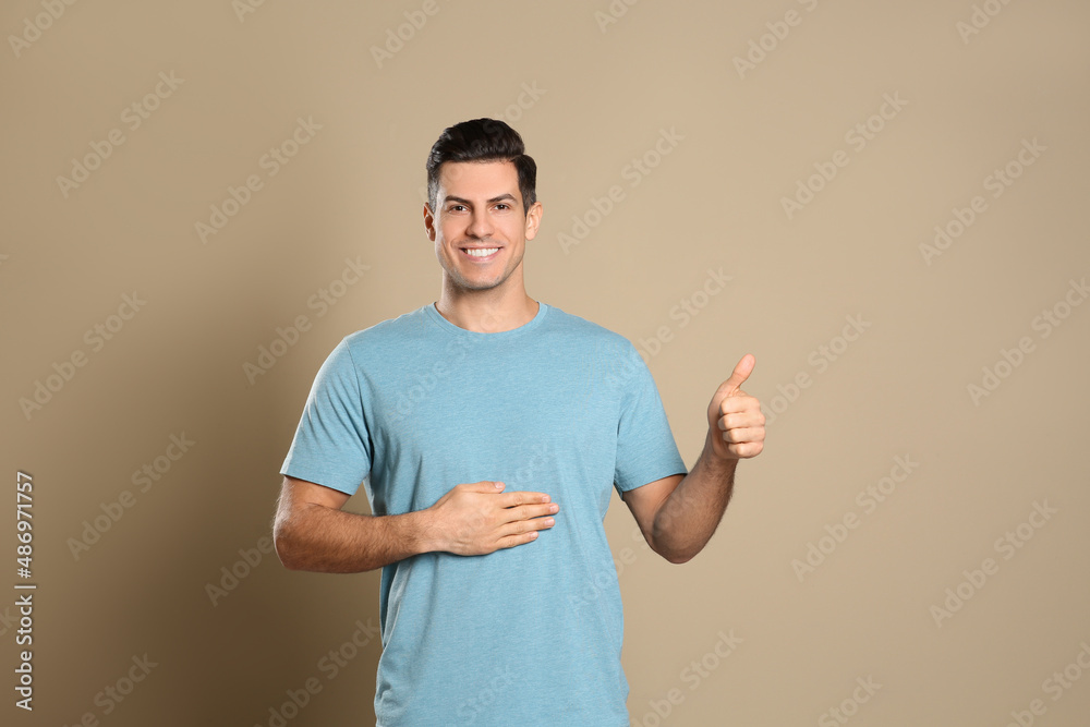 Happy healthy man touching his belly on beige background Happy healthy man touching his belly on beige background