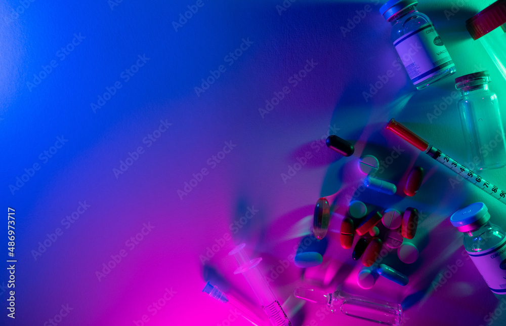 Pharmaceutical background. Coronavirus drug. Lab research. Neon light vaccine jab dose bottle syringe pills test tube arrangement on bright pink blue colorful empty space. - obrazy, fototapety, plakaty 