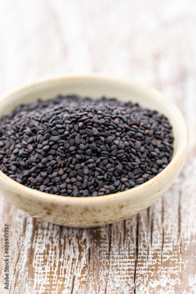 Bio natural black sesame seeds on white bowl. Bio natural black sesame seeds on white bowl.