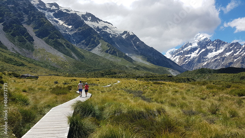 Two boys on a walking track in a valley among the mountains at Mount Cook National Park, New Zealand