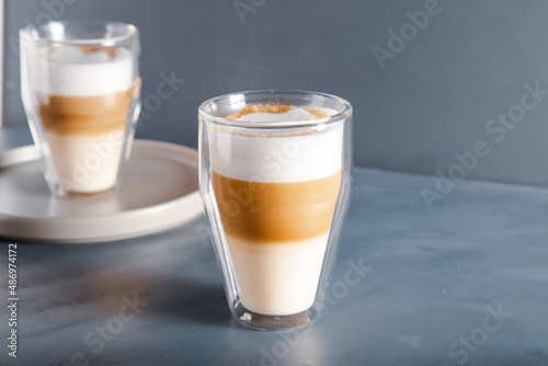Perfectly gradient latte macchiato view over grey backdrop with copy space.