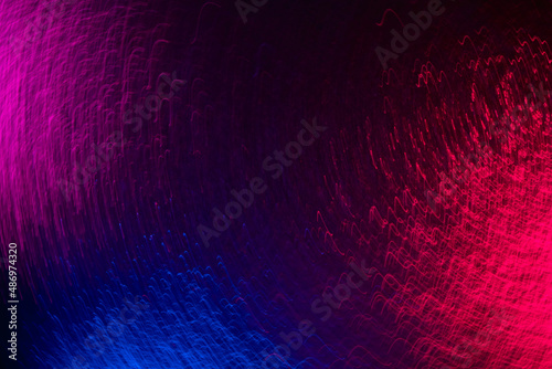 Blur neon glow. Colorful background. Party illumination. Defocused fluorescent blue pink purple light wavy lines texture vibration on dark black abstract overlay.
