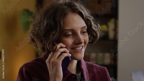 A young lady is talking with someone on the phone