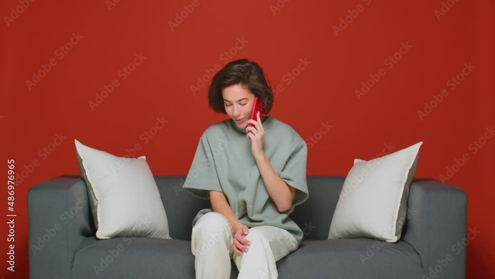 A happy young brunette is chatting with a friend on the phone, sharing good news. Talking on a smartphone with relatives. Cellular communication. A happy young brunette is chatting with a friend on the phone, sharing good news. Talking on a smartphone with relatives. Cellular communication.