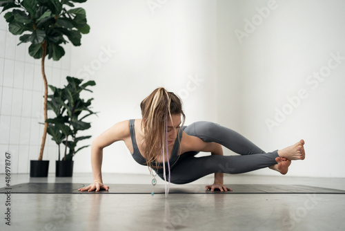 Fototapeta Naklejka Na Ścianę i Meble -  Yoga training a woman does asana on a mat. Healthy lifestyle concept