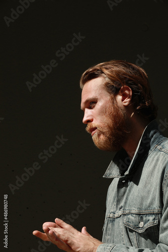 Fototapeta Naklejka Na Ścianę i Meble -  Headshot of thoughtful bearded man posing outdoor wears denim jacket. Vertical.
