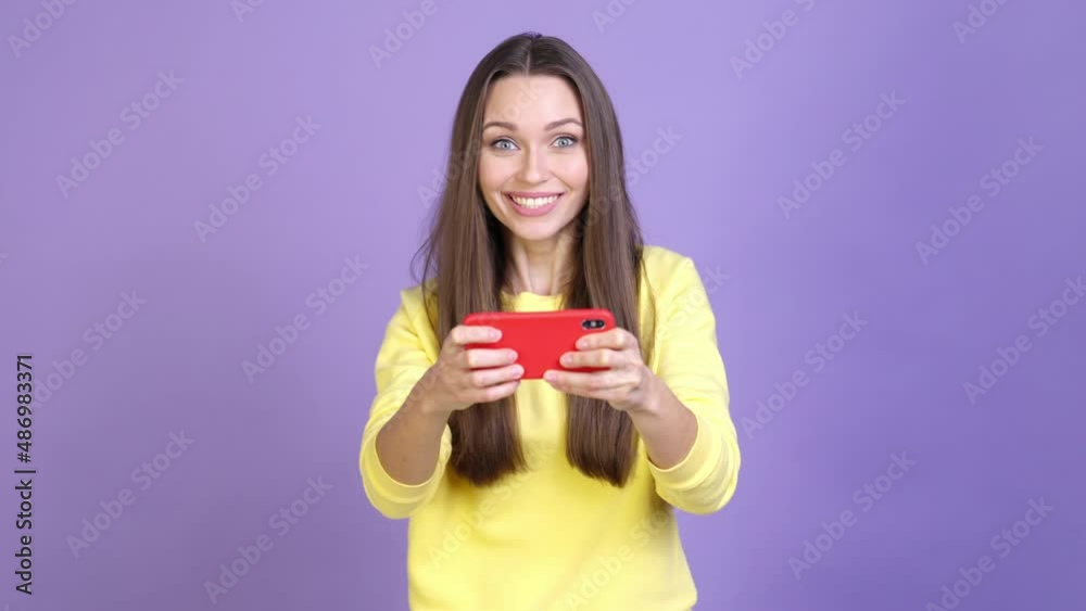 Excited crazy lady play device fist up isolated vivid color background Excited crazy lady play device fist up isolated vivid color background