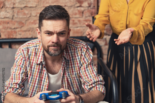 sassy man in his 40s with facial hair ignores his relative who is asking for help. High quality photo