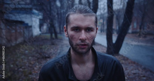 sullen young man walks down the street during the snow with a crumpled face in a bad condition, having abandoned the last hope. Bad-looking man with an emotion of indifference on his face.