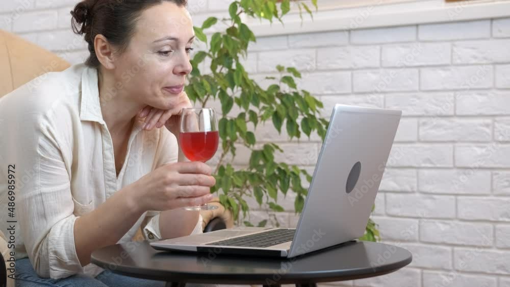 Quarantined meeting with wine. A woman meet her friends online and drink wine with them in the room. Quarantined meeting with wine. A woman meet her friends online and drink wine with them in the room.