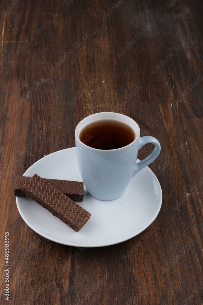 Chocolate Wafer on Wooden Plate, Served with Tea, Copy Space Chocolate Wafer on Wooden Plate, Served with Tea, Copy Space