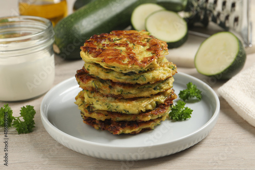Schilderij op canvas Delicious zucchini fritters served on wooden table
