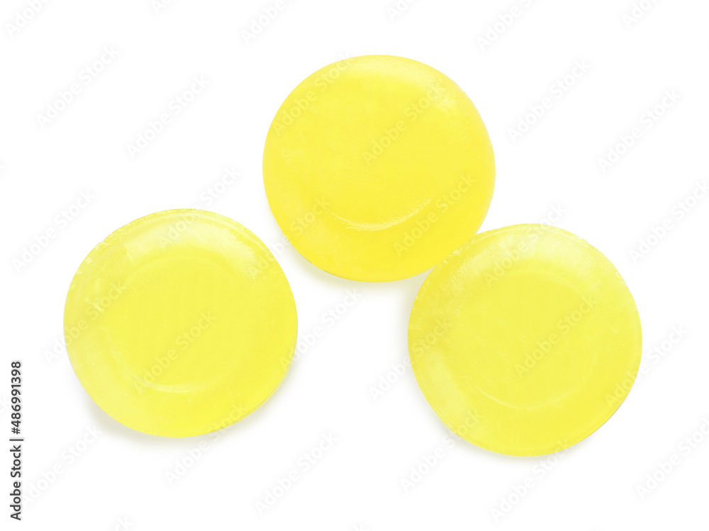 Three yellow cough drops on white background, top view Three yellow cough drops on white background, top view