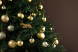 Beautifully decorated Christmas tree on brown background, closeup. Space for text