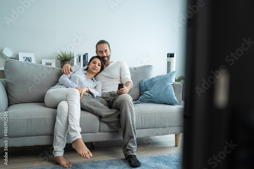 Caucasian loving couple watch movie together in living room at home. 