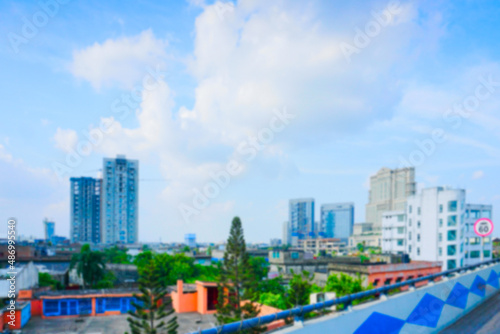 Blurred image of Kolkata, West Bengal, India. Kolkata cityscape , old and modern architecture of buildings, blue sky and white clouds in background.