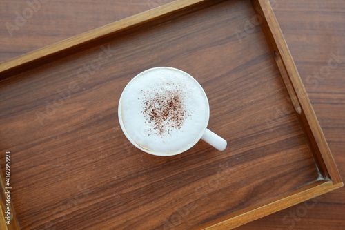Top view cup cappuccino on wooden tray.