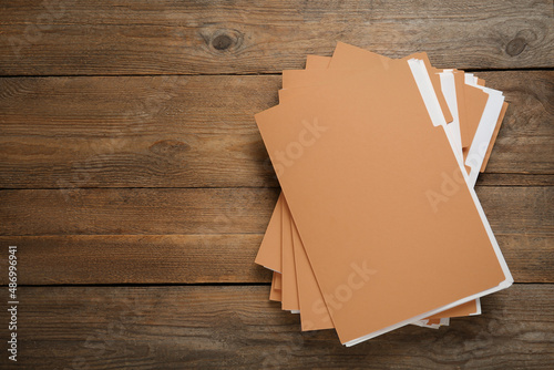 Fotografía Yellow files with documents on wooden table, top view