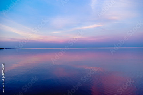 Beautiful sunset on sea, pastel colors and reflections on water, calm nature landscape with colorful clouds © yrabota