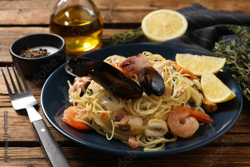 Delicious pasta with sea food served on wooden table