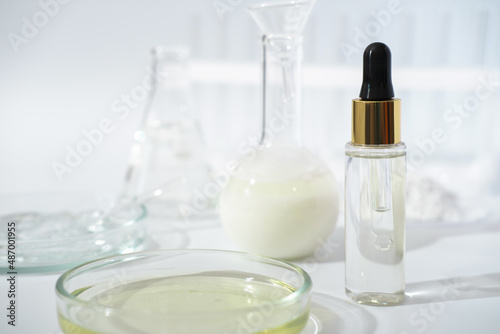 laboratory dishes and glassware on a lab table. fermentation, fermented beauty skin care. dropper bottle of solution or serum for anti age treatment.