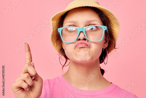 Young woman wearing a panama hat and glasses posing isolated background