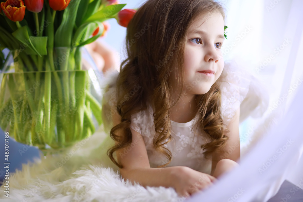 Beautiful girl in white dresses with a magnificent bouquet of the first tulips. International Women's Day. Girl with tulips. Beautiful girl in white dresses with a magnificent bouquet of the first tulips. International Women's Day. Girl with tulips.